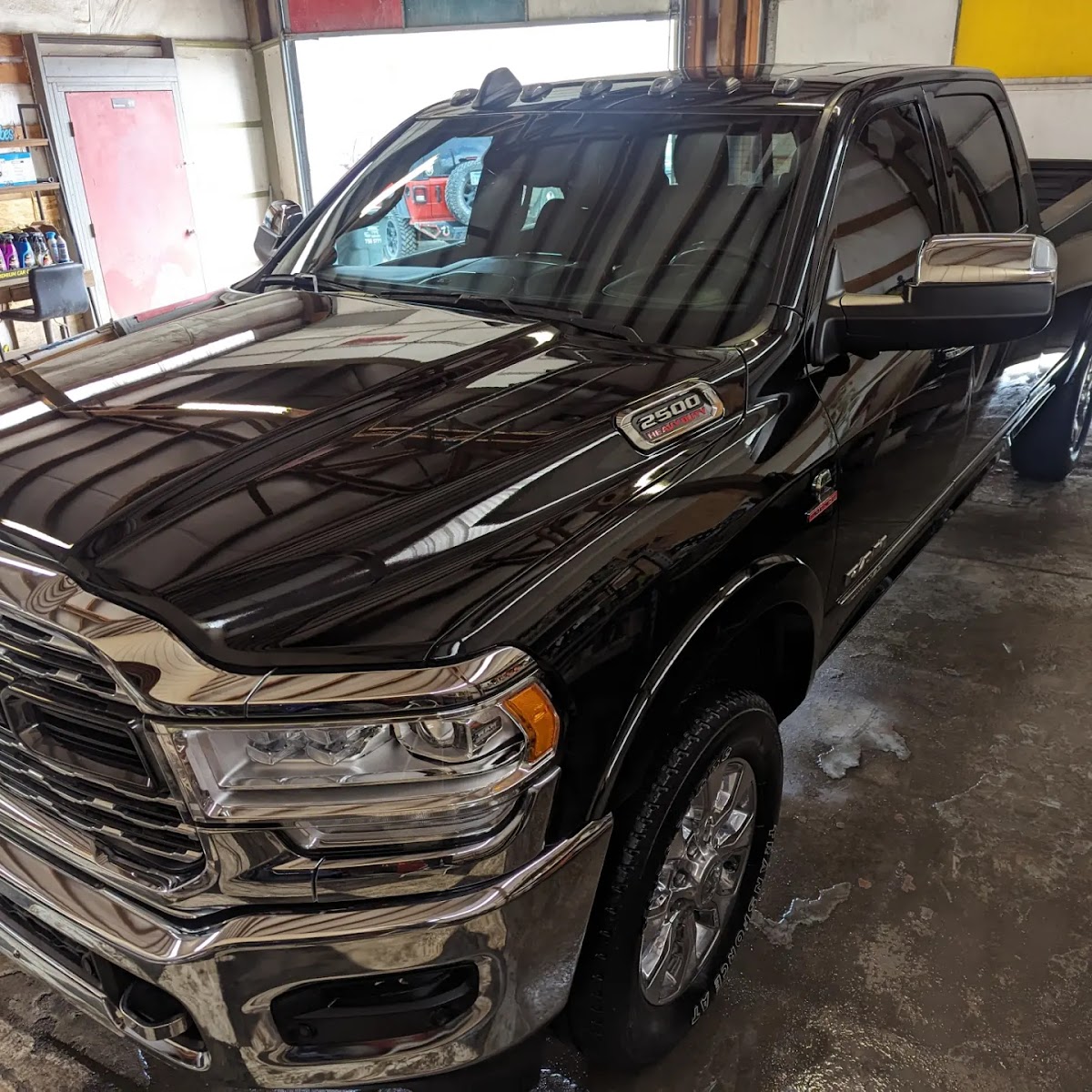 Mirror-finish black Ram 2500 reflecting the shop after a Good Vibes detail